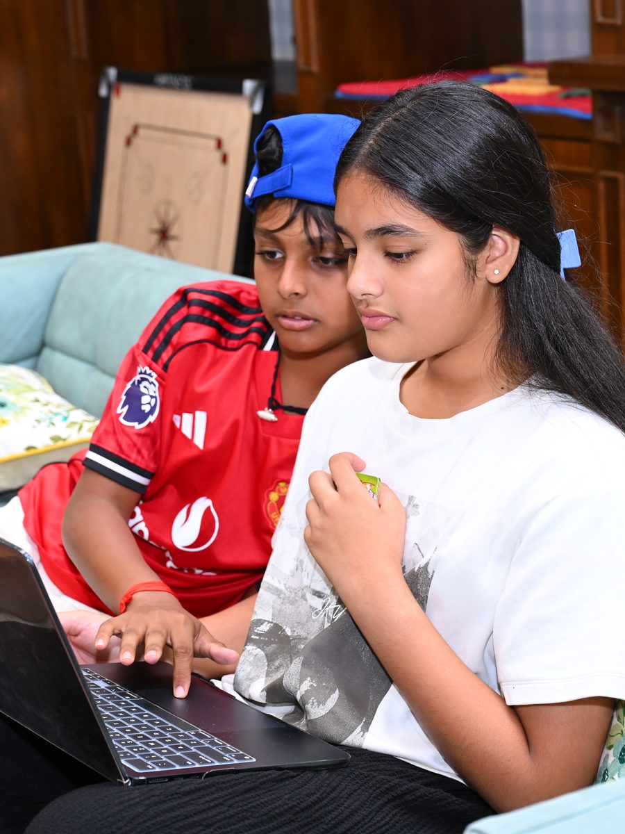 Two friends sharing a laptop in the boarding house
